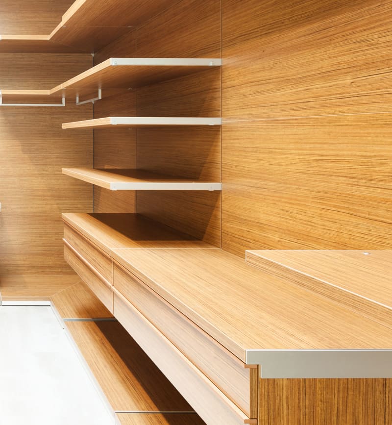 Moderne Schrankwand mit Holzregalen und Schubladen, ausgestattet mit mehreren Ebenen und minimalistischem Design